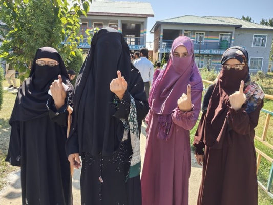 Female voters proudly showing their inked fingers after casting their vote.